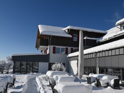 Schneebedeckte Außenansicht des Sontheim's Naturhotel & Spa in Maierhöfen im Winter.