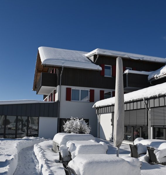 Schneebedeckte Außenansicht des Sontheim's Naturhotel & Spa in Maierhöfen im Winter.