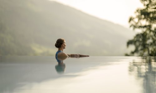 Eine Dame genießt den Ausblick im Außenpool im Hotel Prinz-Luitpold-Bad in Bad Hindelang.