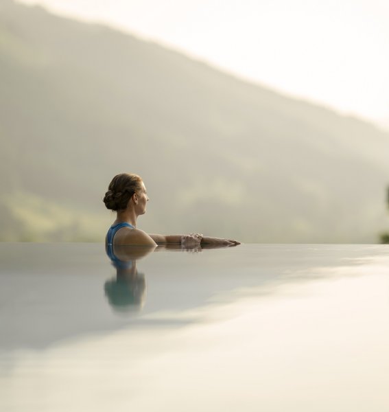 Eine Dame genießt den Ausblick im Außenpool im Hotel Prinz-Luitpold-Bad in Bad Hindelang.