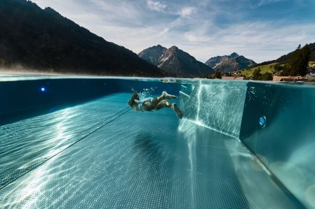 Ein Gast taucht im Infinitypool im A-ROSA Ifen Hotel Kleinwalsertal.