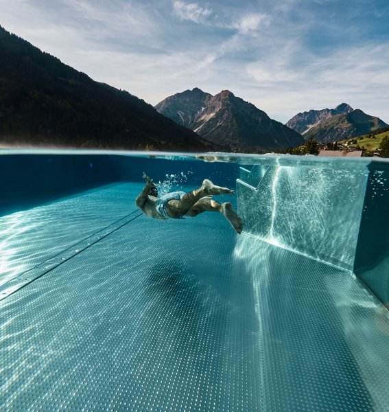 Ein Gast taucht im Infinitypool im A-ROSA Ifen Hotel Kleinwalsertal.