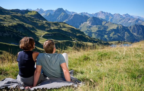 Ein Paar genießt den Ausblick vom Berggipfel beim Wandern.