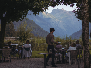 Gäste sitzen abends auf der Terrasse im Hotel Kühberg in Oberstdorf.