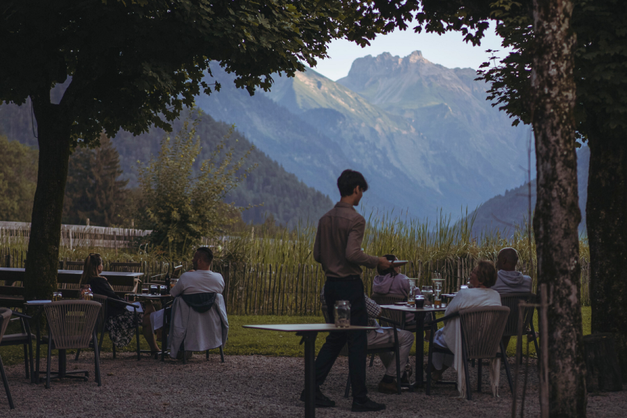 Gäste sitzen abends auf der Terrasse im Hotel Kühberg in Oberstdorf.