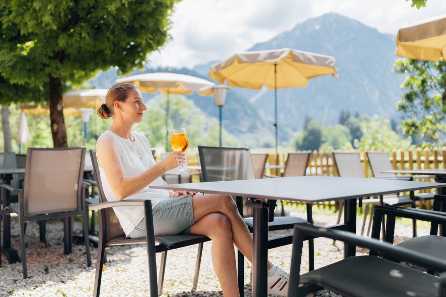 Eine Dame trinkt einen Aperol auf der Terrasse im Hotel Prinz-Luitpold-Bad in Bad Hindelang.