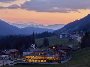 Blick auf das HUBERTUS Mountain Refugio Allgäu in Balderschwang bei Sonnenuntergang.