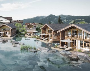 Zu sehen ist eine Übersicht von 3 Chalets, Berge im Hintergrund und direkt am Teich gelegen.