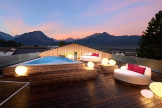Außenpool bei Sonnenuntergang auf dem Dach im Hotel Franks in Oberstdorf.