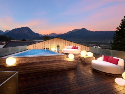 Außenpool bei Sonnenuntergang auf dem Dach im Hotel Franks in Oberstdorf.