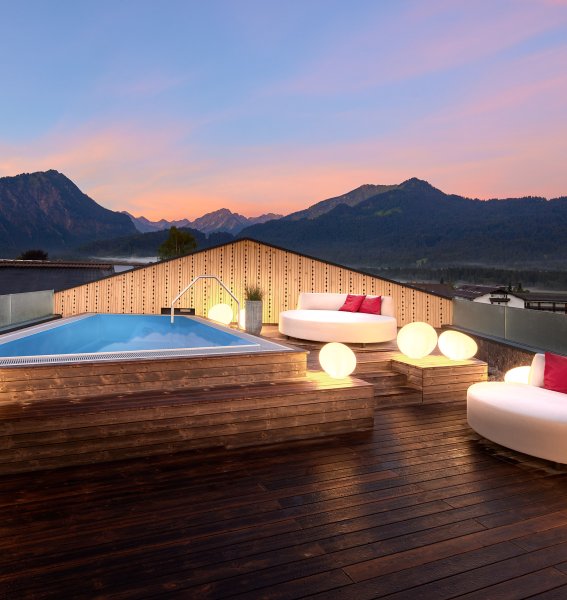 Außenpool bei Sonnenuntergang auf dem Dach im Hotel Franks in Oberstdorf.