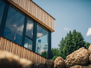 Ein Mann blickt aus einem Fenster im Wellnessbereich im Torgheles Wald und Fluh in Balderschwang.