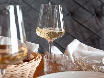 Ein Weißwein wird in ein Glas eingeschenkt im Restaurant in Torgheles Wald und Fluh