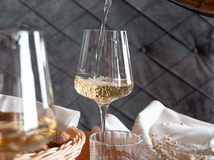 Torghele's Wald & Fluh Kulinarik Ein Weißwein wird in ein Glas eingeschenkt im Restaurant in Torgheles Wald und Fluh
