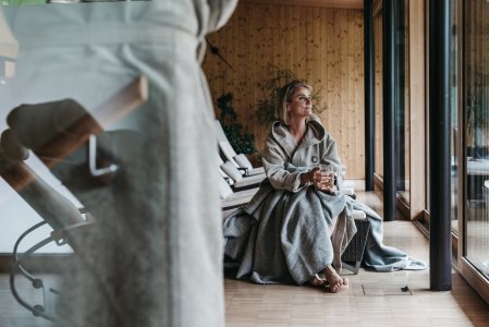 Eine Dame im Bademantel im Wellnessbereich im Naturhotel Chesa Valisa in Hirschegg.