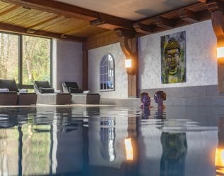 Ein Paar schwimmt im Innenpool im Hotel Ludwig Royal in Oberstaufen.