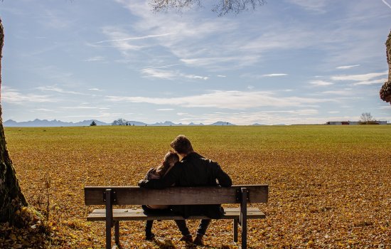Das Weitblick Allgäu Herbst Gäste sitzen auf einer Bank und schauen in die Ferne im Herbst in der Nähe des Hotels Das Weitblick Allgäu in Marktoberdorf.