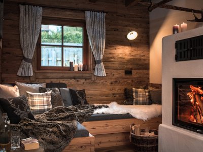 Blick auf den Kamin und eine gemütliche Sitzecke in den Alpzitt Chalets im Dorf in Burgberg.