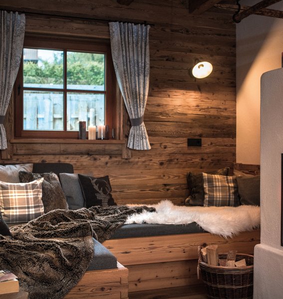 Blick auf den Kamin und eine gemütliche Sitzecke in den Alpzitt Chalets im Dorf in Burgberg.