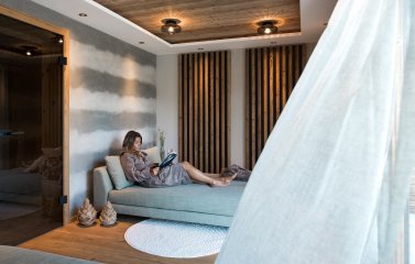 Eine Dame liest ein Buch in den Alpzitt Chalets im Dorf in Burgberg.