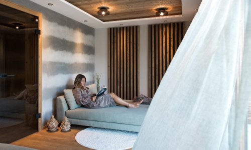 Eine Dame liest ein Buch in den Alpzitt Chalets im Dorf in Burgberg.