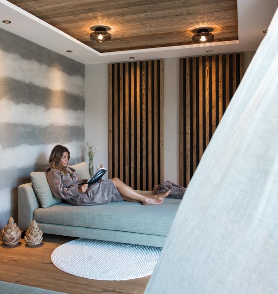 Eine Dame liest ein Buch in den Alpzitt Chalets im Dorf in Burgberg.