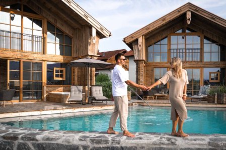Ein Paar am Pool in den Alpzitt Chalets in Burgberg.