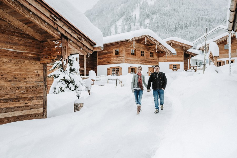 Alpzitt Chalets im Dorf Winter Ein Paar spaziert durch den Schnee im Winter in den Alpzitt Chalets in Burgberg