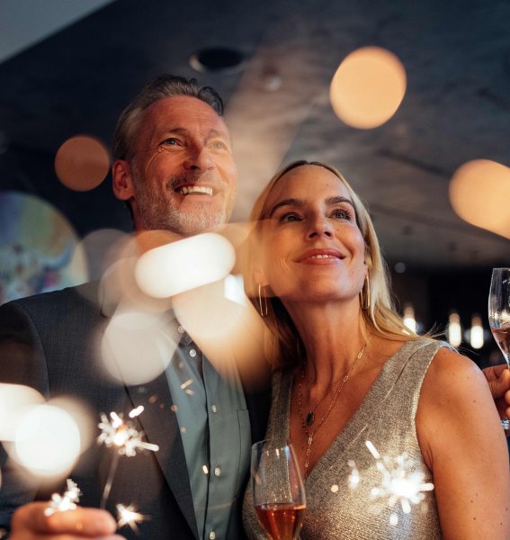 Ein Paar mit Wunderkerzen und Sekt an Silvester im A-ROSA Ifen Hotel Kleinwalsertal in Hirschegg.