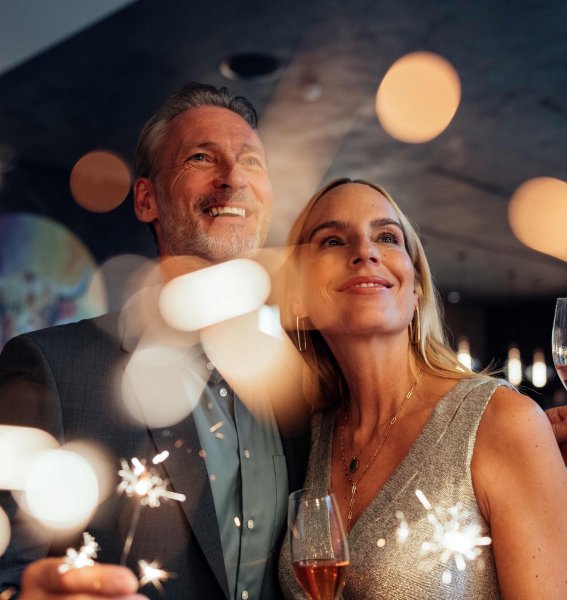 Ein Paar mit Wunderkerzen und Sekt an Silvester im A-ROSA Ifen Hotel Kleinwalsertal in Hirschegg.