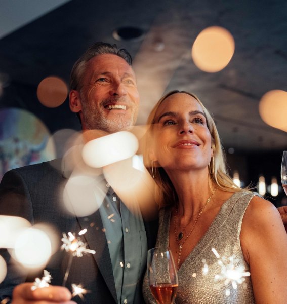 Ein Paar mit Wunderkerzen und Sekt an Silvester im A-ROSA Ifen Hotel Kleinwalsertal in Hirschegg.
