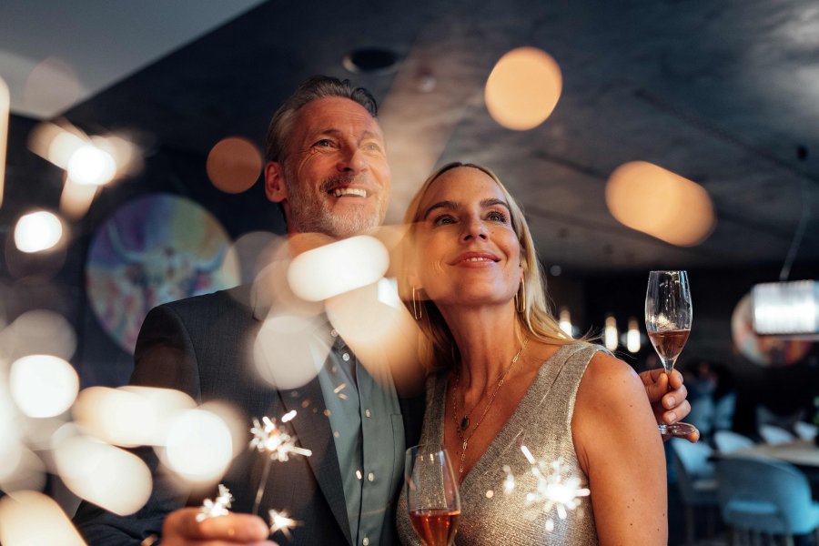 A-ROSA Ifen Hotel Kleinwalsertal Silvester Ein Paar mit Wunderkerzen und Sekt an Silvester im A-ROSA Ifen Hotel Kleinwalsertal in Hirschegg.