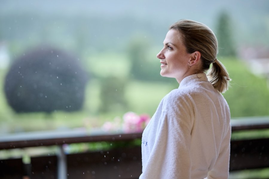 SCHÜLE'S Gesundheitsresort & Spa Wellness Ein Gast im Bademantel auf der Terrasse im SCHÜLE'S Gesundheitsresort und Spa in Oberstdorf.