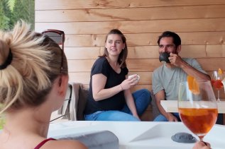 Gäste trinken einen Kaffee und einen Aperitif auf dem Balkon im Wald & Wiesn Berghotel Balderschwang.