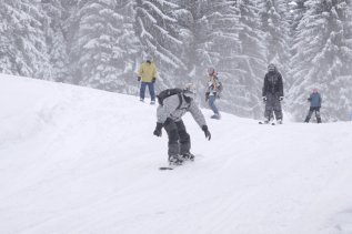 Gäste beim Snowboadfahren im Wald & Wiesn Berghotel Balderschwang.