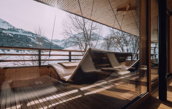 Eine Hängeliege auf dem Balkon im Wellnessbereich im Winter im Naturhotel Chesa Valisa im Kleinwalsertal.