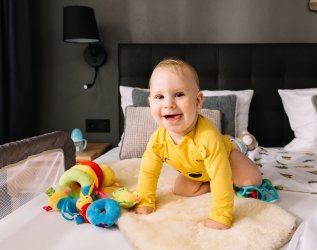 Ein Baby auf dem Bett im Zimmer des Mondi Resort Oberstaufen.
