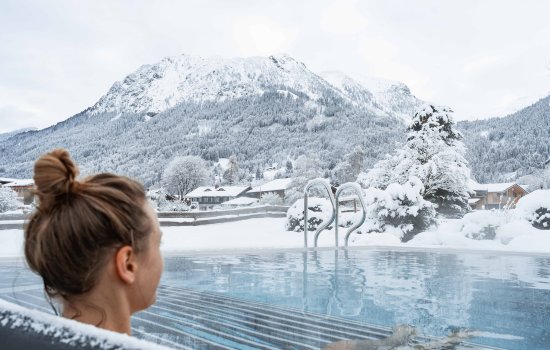 Hotel Franks Außenpool Winter Eine Dame entspannt im Außenpool im Hotel Franks im Winter in Oberstdorf.
