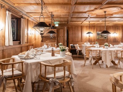 Sonnenalp Resort Restaurant Gemütliche Stube in einem der Restaurants im Sonnenalp Resort in Ofterschwang mit Holzverkleidung und festlicher Tischdekoration