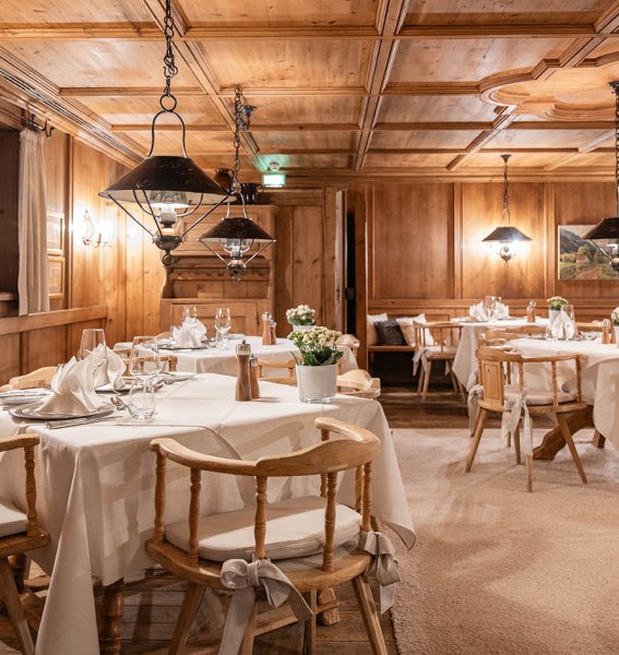 Sonnenalp Resort Restaurant Gemütliche Stube in einem der Restaurants im Sonnenalp Resort in Ofterschwang mit Holzverkleidung und festlicher Tischdekoration