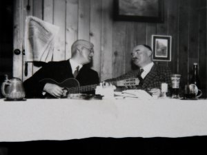 Ein historisches Bild von zwei Männern die zusammen an einem Tisch im Hotel Prinz-Luitpold-Bad in Bad Hindelang sitzen und musizieren