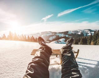Schlittenfahren bei Sonnenschein in der Nähe des Hartungs Hoteldorf in Hopfen am See.