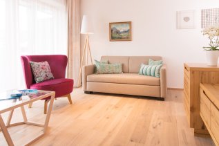Einblick in eines der Zimmer im Hotel Hahnenköpfle in Oberstdorf mit Blick auf ein gemütlich wirkendes Sofa und Sessel