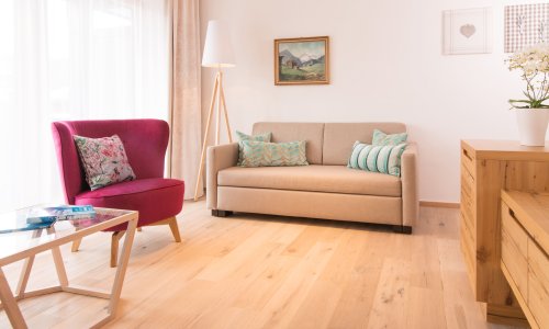 Einblick in eines der Zimmer im Hotel Hahnenköpfle in Oberstdorf mit Blick auf ein gemütlich wirkendes Sofa und Sessel