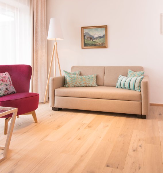 Einblick in eines der Zimmer im Hotel Hahnenköpfle in Oberstdorf mit Blick auf ein gemütlich wirkendes Sofa und Sessel