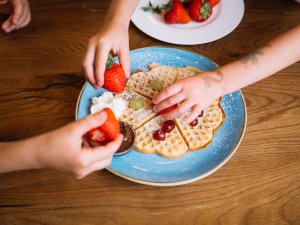 Kinder essen Waffeln mit Obst im Mondi Resort Oberstaufen.