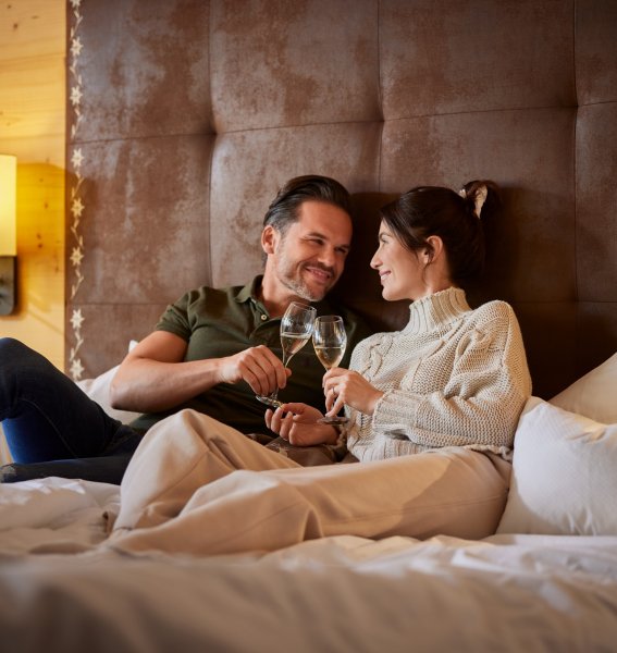 Gäste trinken eine Sekt im Bett im Hanusel Hof in Hellengerst.