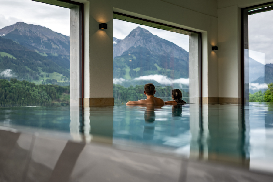 Das Tanneck Innenpool Ein Paar entspannt im Innenpool mit Bergblick im Hotel das Tanneck in Fischen.