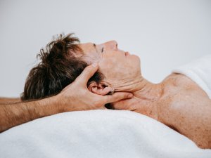 Eine Frau erhält eine Behandlung am Kopf im Rosenalp Gesundheitsresort & Spa in Oberstaufen