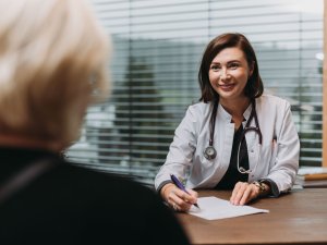 Ein Gast erhält eine Beratung von einer Mitarbeiterin im Rosenalp Gesundheitsresort & Spa in Oberstaufen
